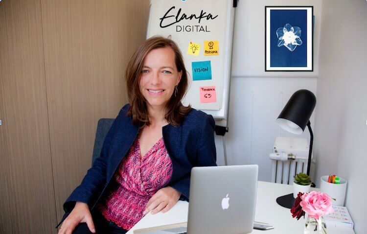 Adélaïde Malthet, experte en stratégie digitale et e-commerce, créatrice de l'agence Elanka, photographiée à son bureau, macbook ouvert, à l'arrière un panneau avec des post-it vision, persona, idées, ...